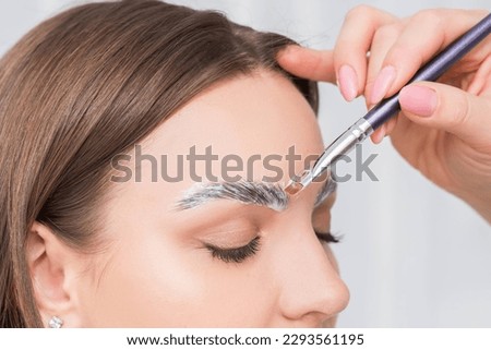 Process of long-lasting styling of the eyebrows and coloring the eyebrows. Eyebrow lamination. Professional make-up and face care. Royalty-Free Stock Photo #2293561195