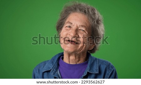 Closeup portrait of smiling happy toothless elderly senior old woman with wrinkled skin and grey hair isolated on green screen background in studio. Emotions concept Royalty-Free Stock Photo #2293562627