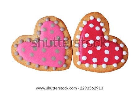 Pair of lovely dotted patterned royal icing heart shaped cookies on white background