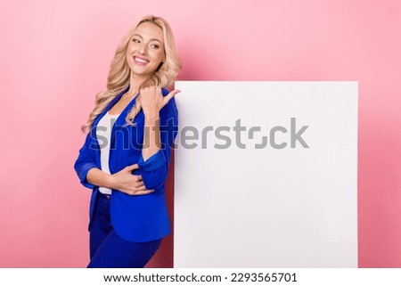 Photo of adorable pretty lady wear blue jacket looking pointing thumb poster empty space isolated pink color background