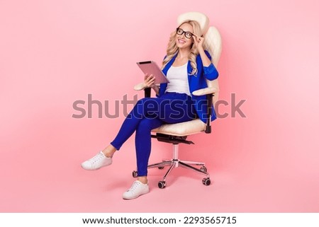 Full photo of young businesswoman touch eyeglasses chair hold notepad wear blue suit look empty space google search isolated on pink color background