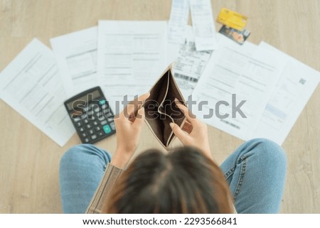 Stressed and headache woman with large bills or invoices no money to pay to expenses and credit card debt. shortage, Financial problem, bankruptcy, mortgage, loan, bankrupt, poor, empty wallet  Royalty-Free Stock Photo #2293566841
