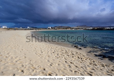 White sand, blue water and stormy clouds on La Concha beach, El Cotillo surfer's village, Fuerteventura, Canary islands, Spain