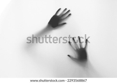 Defocused hand silhouette behind frosted glass in black and white mode, halloween concept
 Royalty-Free Stock Photo #2293568867