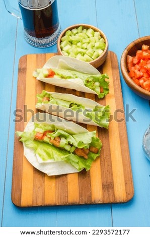 Mexican tacos with vegetables and meat. Ingredient for cooking tacos al pastor on blue background. Top view.