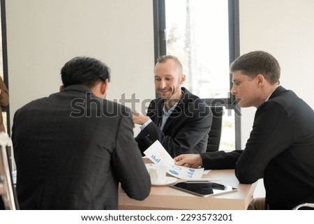 Investment advisor meeting of three businessmen analyzing company financial report, balance sheet, working with chart papers for stock market. Office