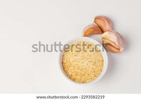 Dry garlic powder in white bowl and garlic cloves isolated top view with copy space Royalty-Free Stock Photo #2293582219