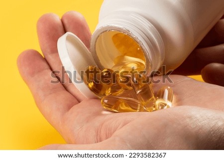 closeup hand holding fish oil vitamin for healthy. Royalty-Free Stock Photo #2293582367