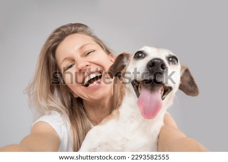 Happy friends dog and woman. Cute funny friends. focus on the face of a woman, muzzle of dog in defocus. Happy exited portrait of blonde dog owner girl and her adorable Jack Russell terrier pet  Royalty-Free Stock Photo #2293582555