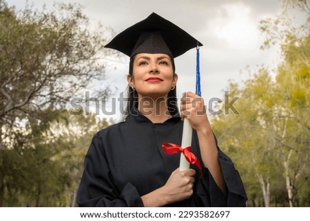 close up latina student looking straight ahead holding her degree on graduation day. graduation concept Royalty-Free Stock Photo #2293582697