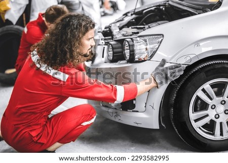 Mechanic garage auto workshop team working service repair fix damaged front bumper accident car Royalty-Free Stock Photo #2293582995
