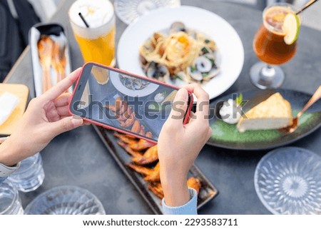 Woman taking photo on cellphone with dish