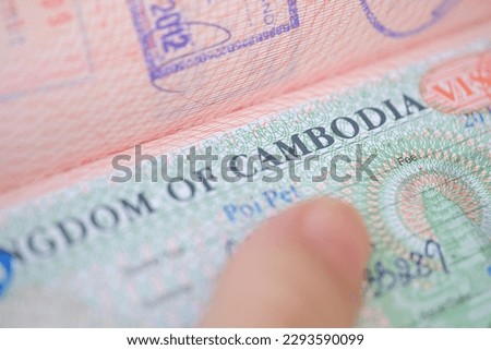 close-up part of page of document, foreign passport for travel with Cambodia visa, tourist visa stamp with hologram with shallow depth of field, passport control at border, travel in Southeast Asia