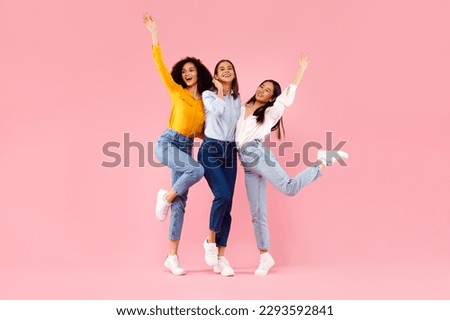Female friendship concept. Joyful diverse ladies embracing and having fun, smiling at camera, friends posing together over pink studio background, full length, free space Royalty-Free Stock Photo #2293592841