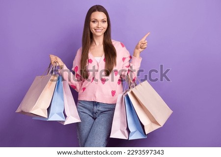Photo of pretty cute girl wear berry print cardigan rising shoppers pointing empty space isolated violet color background