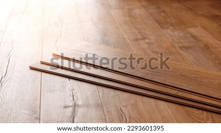 Installing laminated or wood parquet on floor, wooden tile. Royalty-Free Stock Photo #2293601395
