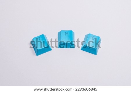 
Word "THE" written on blue computer keycaps keys isolated dynamic composition on a white background. 
