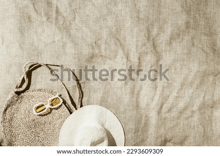 Summer vacation, beach rest concept, minimal style aesthetic flat lay fashion straw beach bag and trend yellow sunglasses on beach towel at sunlight, vintage toned photo, top view, copy space