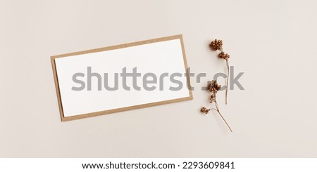 Top view blank white paper card and craft paper envelopment, autumn letter  with copy space for text, autumn greeting or invitation card with trend dry flower, fall beige brown colors still life photo
