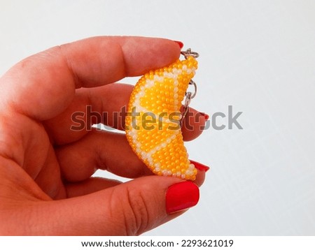 Bright key chain lies on a woman's palm. Colorful keychain lies on a woman's palm