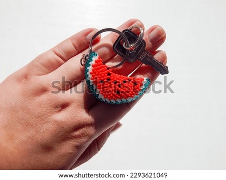 Bead colorful key chain in hand. Bright key chain in a female hand