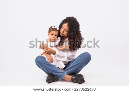 Happy loving family. Mother with baby girl on her lap on endless background. Happy Mothers Day