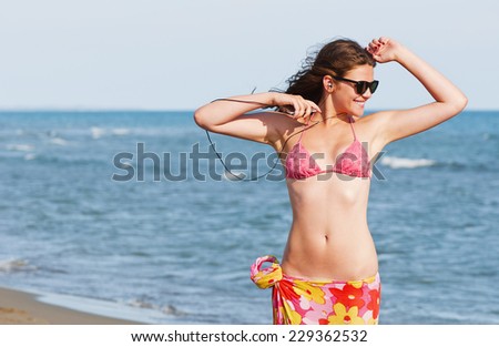 Young woman enjoying music on the beach