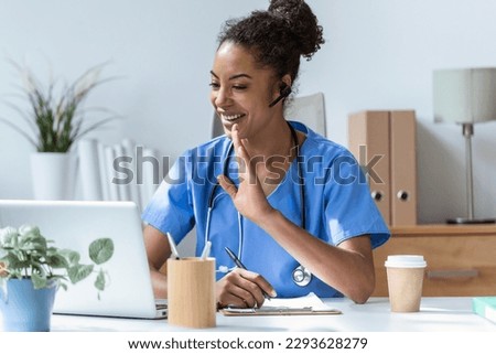 Shot of beautiful female doctor talking with colleagues through a video call with a laptop in the consultation. Royalty-Free Stock Photo #2293628279