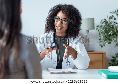 Shot of beautiful cheerful female doctor talking while explaining medical treatment to patient in the consultation. Royalty-Free Stock Photo #2293628313