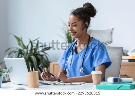 Shot of beautiful female doctor talking with colleagues through a video call with a laptop in the consultation. Royalty-Free Stock Photo #2293628315