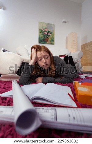 A girl falling asleep when trying to study for shool