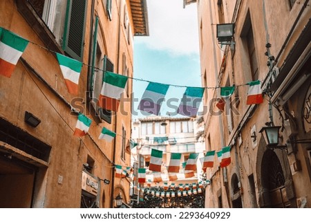 Holiday in the Italian city of streets with Italian flags and ancient buildings. Pisa, Italy. High quality photo Royalty-Free Stock Photo #2293640929