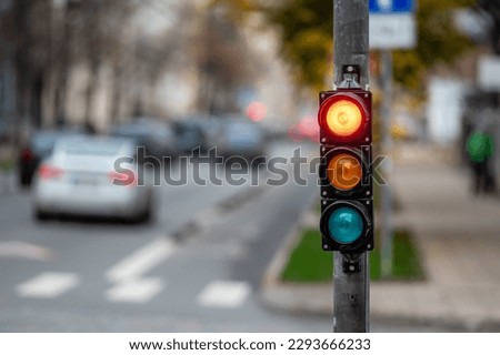 view of city traffic with traffic lights, in the foreground a semaphore with a red light Royalty-Free Stock Photo #2293666233