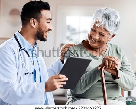 It was nothing to worry about. Shot of a young doctor sharing information from his digital tablet with an older patient. Royalty-Free Stock Photo #2293669295