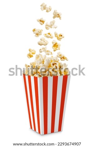 Popcorn flying out of red white striped paper box isolated on white background with copy space. Splash, levitation of popcorn grains.  Royalty-Free Stock Photo #2293674907