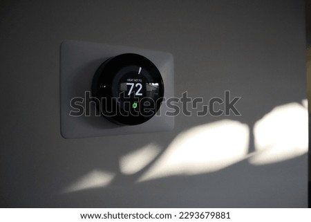 Thermostat in a house at sundown Royalty-Free Stock Photo #2293679881