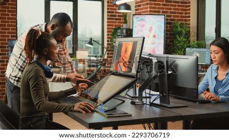 Game industry developers working on artistic development design with multiple displays on desk. Team of production department employees developing artificial intelligence technology. Royalty-Free Stock Photo #2293706719
