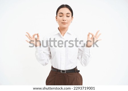 Wellbeing and workplace. Young asian businesswoman meditates, keeps calm, relaxes after work, white background.
