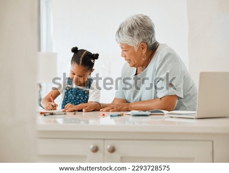 Can I draw too. Shot of a grandma helping her granddaughter at the kitchen table at home.
