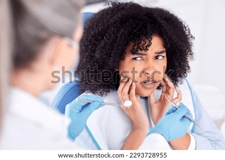 .. Shot of a young woman experiencing pain and anxiety while having a dental procedure performed on her. Royalty-Free Stock Photo #2293728955