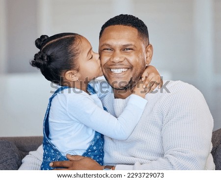 Adorable little girl kissing her dad on the cheek. African american man laughing and looking joyful while receiving love and affection from his daughter. Man being spoiled on fathers day