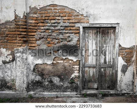 Background texture of Old house with old wooden door and damaged brick wall, scary, haunted house, spooky.traditional house