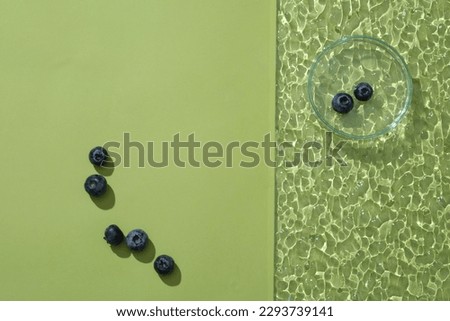 Acrylic sheet with a glass petri dish of blueberries placed on. Pastel background with blank space for product presentation extracted from Blueberry. Copy space