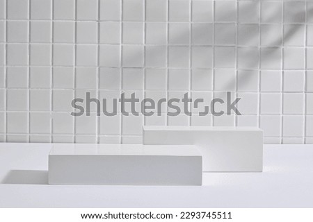 A set of empty gray round podiums decorated on mosaic tiles background. Pedestal or platform for beauty products presentation