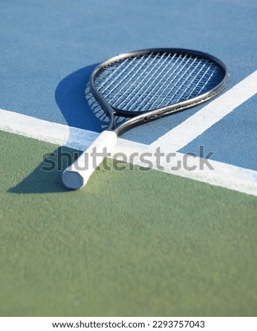 Today is to be used to be better. Shot of a tennis racket on a court during the day.