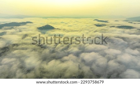 Aerial view of the Xuan Tho suburbs near Da Lat city at morning with misty sky in Vietnam highlands. Urban development texture, transport infrastructure, greenhouse in agriculture