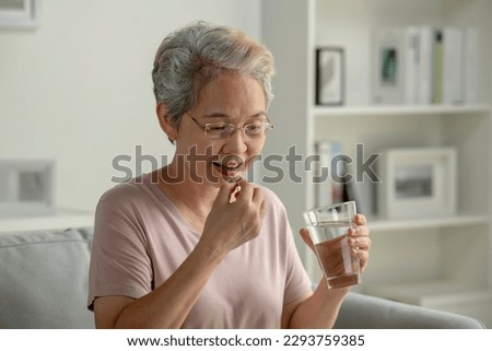 Asian senior woman taking medicine at home, age, medicine, healthcare and people concept Royalty-Free Stock Photo #2293759385