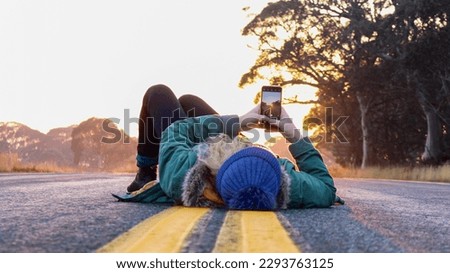 Woman lying on empty taking photos on sunrise.
