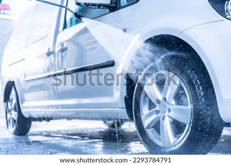 Manual car wash with white soap, foam on the body. Washing Car Using High Pressure Water.