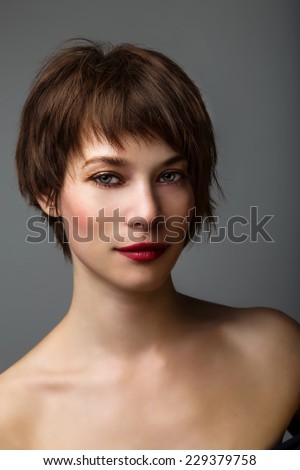 Side portrait of a young woman with short brown hair and brown glowing eyes. Royalty-Free Stock Photo #229379758